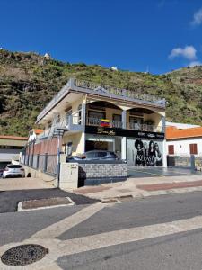 ein Gebäude an der Seite einer Straße mit einem Berg in der Unterkunft Nature Brava Stay in Ribeira Brava