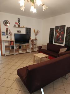 a living room with a couch and a flat screen tv at 1000MigliaHouse in Brescia