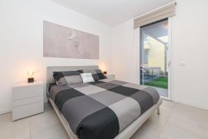 een slaapkamer met een zwart-wit bed en een raam bij MGH- Grace Apartment Katya Resort in Rivoltella +28 foto's