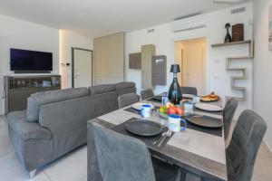 een woonkamer met een tafel en een bank bij MGH- Grace Apartment Katya Resort in Rivoltella
