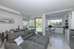 een woonkamer met een bank en een keuken bij MGH- Grace Apartment Katya Resort in Rivoltella