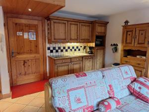 a living room with a couch and a kitchen at Les Airelles A21 in Les Menuires