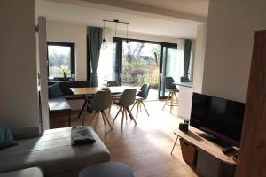 a living room with a couch and a table with chairs at Haus am Fluss in Bad Freienwalde