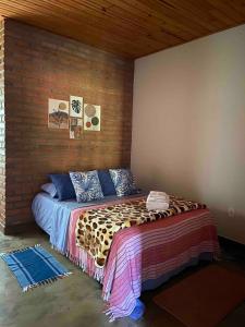 a bed in a room with a brick wall at São João da Colina Ranch ItamonteMG in Itamonte