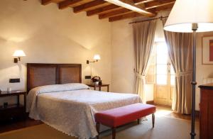 a bedroom with a bed and a large window at Hotel Rural Palacio de Prelo in Boal
