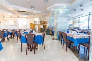 a dining room with blue tables and chairs at Hotel Astor in Alba Adriatica