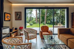 ein Wohnzimmer mit einem Sofa, Stühlen und einem Glastisch in der Unterkunft Bread et Couette in Lyon