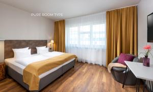 a hotel room with a bed and a chair at SORAT Hotel Berlin in Berlin
