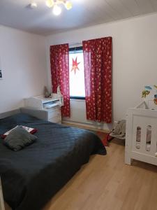 Un dormitorio con una cama y una ventana con cortinas rojas. en Sulli apartment, en Rovaniemi
