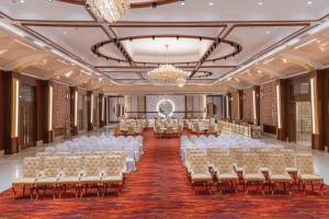 un salón de banquetes con sillas blancas y una lámpara de araña en Lariya Resort, en Jodhpur 39 fotos más