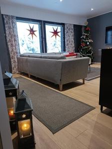 Una sala de estar con un sofá y un árbol de Navidad. en Sulli apartment, en Rovaniemi