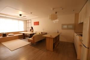 eine Frau sitzt an einem Tisch in einer Küche in der Unterkunft 그리다 교동 in Tongdaegu-yŏk + 33 Fotos