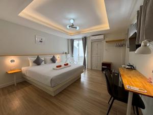 una camera d'albergo con un letto, un tavolo e una scrivania di Priew Wan Guesthouse a Patong Beach Altre 23 foto
