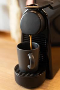 a coffee maker is pouring coffee into a cup at Kyveli Lake Suite in Kastoria