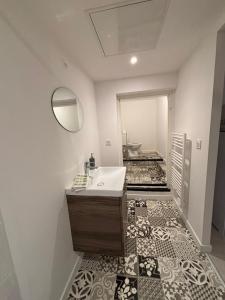 ein Badezimmer mit Waschbecken und Spiegel in der Unterkunft Le Breakaway, cosy et calme in Saint-Junien