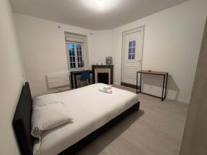 ein Schlafzimmer mit einem Bett und einem Tisch und einem Fenster in der Unterkunft Le Breakaway, cosy et calme in Saint-Junien