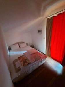 een slaapkamer met een bed en een rood gordijn bij Panorama Borsko jezero in Beljevina