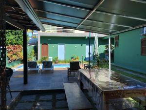 a patio with a table and chairs and a pool at Flats Casa Verde in Saquarema