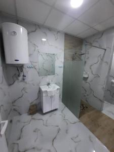 een witte marmeren badkamer met een wastafel en een douche bij Panorama Borsko jezero in Beljevina +20 foto's