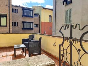 a balcony with a table and chairs on a roof at Appartamenti San Salvatore 1 by Ospitaci in Foligno