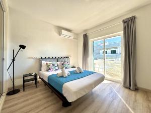een slaapkamer met een bed en een groot raam bij Albufeira Delight with Pool by Homing in Guia +28 foto's