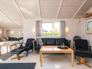 een woonkamer met een bank, stoelen en een tafel bij 6 person holiday home in Haderslev-By Traum in Flovt