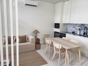 a kitchen and living room with a table and a couch at Villa Graça Olhão in Olhão