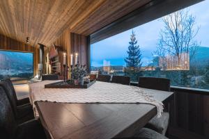 a dining room with a table and a large window at Nyørk Chalet, Hemsedal in Hemsedal