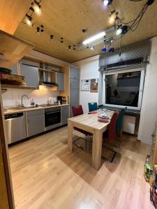 a kitchen with a wooden table and chairs and a table and a kitchen at Gemütliche Altbauwohnungen mit Einzelzimmern und Parkplatz direkt am Haus! in Bochum