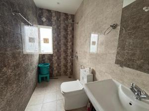 a bathroom with a white toilet and a sink at The Glades 2BHK kasauli in Kasauli +35 photos