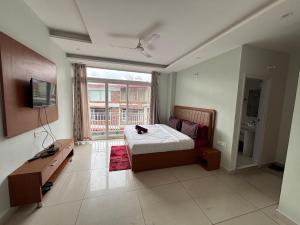 a bedroom with a bed and a desk and a television at The Glades 2BHK kasauli in Kasauli
