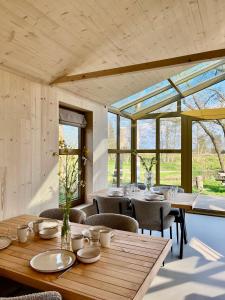 una sala da pranzo con tavoli, sedie e finestre di Large Greenhouse op Boetiekpark de Kas a Scherpenzeel