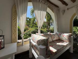 un soggiorno con divano di fronte a una finestra di Charming Cottage in Watamu a Watamu
