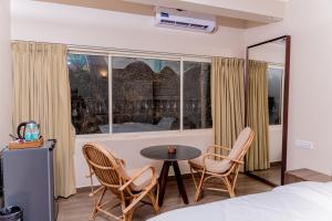 a room with a bed and a table and chairs at Casa Aqua Mandrem in Mandrem