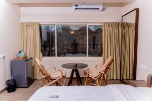 a room with a bed and a table and chairs at Casa Aqua Mandrem in Mandrem