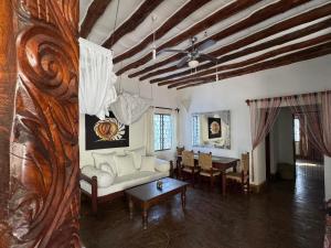 un soggiorno con un divano e un tavolo di Charming Cottage in Watamu a Watamu