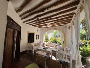 un soggiorno con un divano e un tavolo di Charming Cottage in Watamu a Watamu