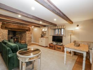 a living room with a couch a table and a tv at Walnut Cottage in Usk