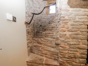 a stone shower in a room with a stone wall at Walnut Cottage in Usk +19 photos