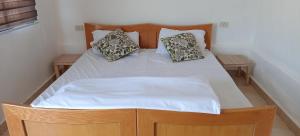 Una cama con sábanas blancas y dos almohadas. en Alnwatif Gate guest house Dana nature reserve, en Dana