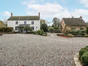 a white house with a gravel driveway at Walnut Cottage in Usk
