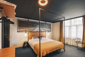 una camera da letto con letto a baldacchino e scrivania di Zoom Hotel a Bruxelles