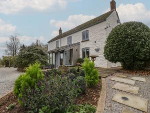 een wit huis met een tuin ervoor bij Tawny Cottage in Llandenny