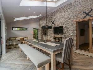 een eetkamer met een stenen muur en een tafel en stoelen bij Tawny Cottage in Llandenny