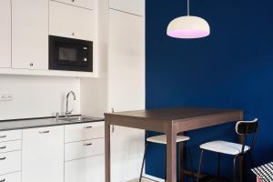 a kitchen with a table and a blue wall at Flamingo Flat - Prague in Prague +25 photos