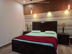 een slaapkamer met een groot bed met een rode deken bij 2 Bedroom Serviced Home in Lahore