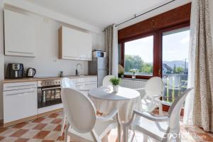 una cucina e una sala da pranzo con tavolo e sedie di Villa Mavi a Drežnik Grad