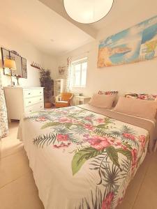 een slaapkamer met een groot bed met een sprei met bloemen bij APARTMENT IN AMARILLA GOLF 2 bedrooms in San Miguel de Abona +26 foto's