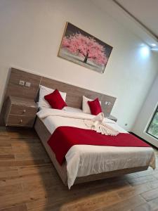 a bedroom with a large bed with red pillows at Hôtel Résidence Ngary in Thiès