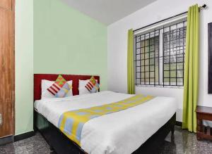 a bedroom with a large bed with a window at LIMRA INN RESIDENCY cottage in Ooty
